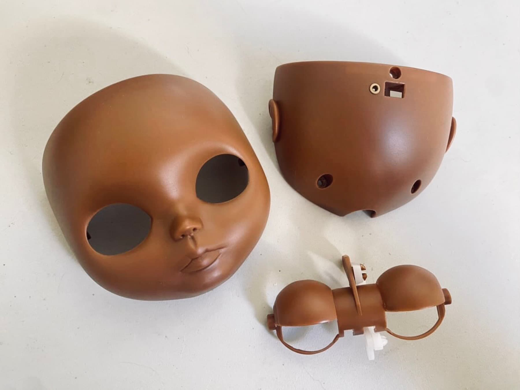 A doll head opened up, the face plate carved and separated from the scalp